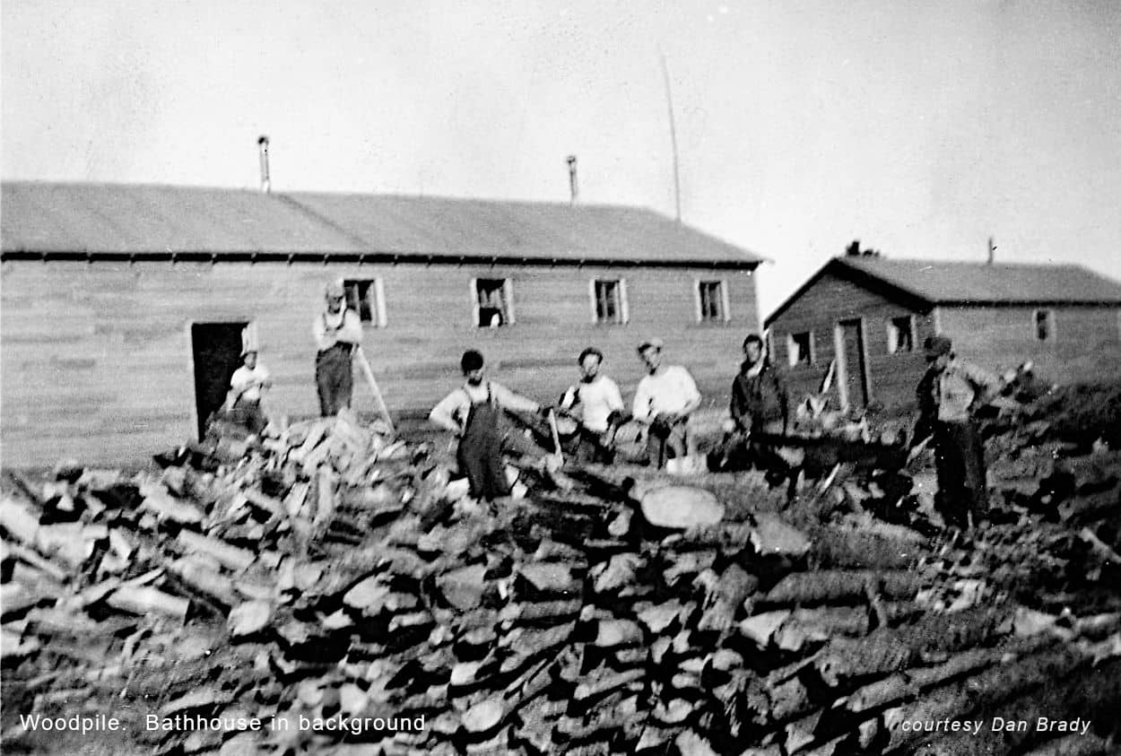 Woodpile. Bathhouse in background